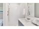 Modern bathroom featuring a white-tiled shower and gray vanity with countertop sink at 3810 Jack Vernon Cir, Powder Springs, GA 30127