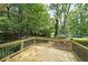 The backyard deck features black iron railings and overlooks the mature trees and foliage at 5807 Christopher Ln, Lithonia, GA 30058