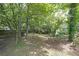 View of the backyard with mature trees, green lawns, and foliage providing a lush landscape at 5807 Christopher Ln, Lithonia, GA 30058