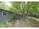 Backyard features a lush lawn and mature trees that surround the home at 5807 Christopher Ln, Lithonia, GA 30058