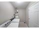 The laundry room features a washer, dryer, water heater and gray wood-look floors at 5807 Christopher Ln, Lithonia, GA 30058