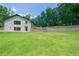 Expansive green backyard featuring a lush lawn, stone retaining wall, and terraced levels at 9701 Buice Rd, Alpharetta, GA 30022