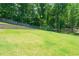 Green backyard with a volleyball net and tiered retaining walls, creating a fun outdoor space at 9701 Buice Rd, Alpharetta, GA 30022