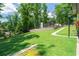 Lush backyard with mature trees, a stone retaining wall, and a winding walkway at 9701 Buice Rd, Alpharetta, GA 30022