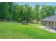 Expansive backyard provides ample green space, an outdoor seating area, and a serene wooded backdrop at 9701 Buice Rd, Alpharetta, GA 30022
