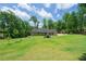 Large, lush backyard with a view of the home's exterior, ideal for Gathering activities and relaxation at 9701 Buice Rd, Alpharetta, GA 30022