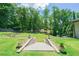 Backyard with terraced stone retaining walls and lush landscaping leading to a treelined view at 9701 Buice Rd, Alpharetta, GA 30022