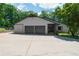 Exterior view of gray home with three car garage, brick accents, and large paved driveway at 9701 Buice Rd, Alpharetta, GA 30022