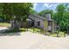 Stylish home exterior with gray brick, stone accents, and a spacious driveway surrounded by manicured landscaping at 9701 Buice Rd, Alpharetta, GA 30022
