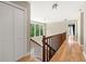 Bright hallway with hardwood floors, staircase, and views of the surrounding greenery at 9701 Buice Rd, Alpharetta, GA 30022