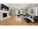 Bright living room with hardwood floors, modern black sofa, fireplace, and large windows at 9701 Buice Rd, Alpharetta, GA 30022