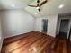 Spacious bedroom features hardwood floors, a ceiling fan, and a view of the bathroom at 2504 Dalesford Ct, Dacula, GA 30019