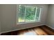 Bedroom with hardwood floors and a large window overlooking a lush green view at 2504 Dalesford Ct, Dacula, GA 30019
