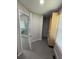 Hallway featuring gray tile flooring and a door leading to a bathroom with a soaking tub and glass shower at 2504 Dalesford Ct, Dacula, GA 30019