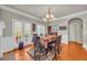 Elegant dining room with hardwood floors, a stylish chandelier, and access to the kitchen and outdoor patio at 2677 Sardis Chase Ct, Buford, GA 30519