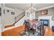 Elegant dining area with hardwood floors, a modern chandelier, a fireplace and adjacent staircase at 2677 Sardis Chase Ct, Buford, GA 30519