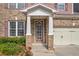 Close-up of the home's inviting front porch, showcasing brick columns, manicured landscaping, and a charming front door at 2677 Sardis Chase Ct, Buford, GA 30519