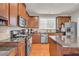 Spacious kitchen featuring wood cabinets, granite countertops, stainless appliances, and center island at 2677 Sardis Chase Ct, Buford, GA 30519