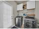 Laundry room features modern washer and dryer, and white cabinets for storage at 2677 Sardis Chase Ct, Buford, GA 30519