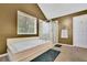 This bathroom features a bright window, soaking tub, and glass shower stall at 502 Allen Dr, Lawrenceville, GA 30043