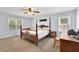 Spacious bedroom with a four-poster bed, neutral walls, and two windows that provide natural light at 502 Allen Dr, Lawrenceville, GA 30043