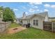 An inviting backyard featuring a patio set, grill, fire pit, lush lawn, and wooden privacy fence at 507 Hillcrest Cross Rd, Canton, GA 30115