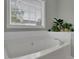 Soaking tub situated beneath a bright window with an elegant silver faucet at 507 Hillcrest Cross Rd, Canton, GA 30115