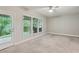 Sunlit bedroom with neutral carpeting, a ceiling fan, and a door to the backyard at 1036 Grant Park Rd, Decatur, GA 30033