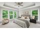 Serene main bedroom featuring large windows, tray ceiling, and a comfortable seating area at 1036 Grant Park Rd, Decatur, GA 30033