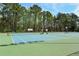 Exterior shot of the well maintained blue and green community tennis courts in a wooded area at 1036 Grant Park Rd, Decatur, GA 30033
