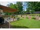 Well-maintained backyard featuring a stone retaining wall, a pergola covered patio, and a lush green lawn at 1777 Chasewood Park Ln, Marietta, GA 30066