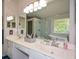 Bright bathroom boasts a double sink vanity with white cabinets, a large mirror, and updated fixtures at 1777 Chasewood Park Ln, Marietta, GA 30066