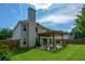 Backyard view with a large two-story home, outdoor patio, tall brick chimney, and a wooden fence at 1777 Chasewood Park Ln, Marietta, GA 30066
