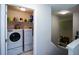 Functional laundry room with washer, dryer, and shelving, conveniently located near the staircase at 1777 Chasewood Park Ln, Marietta, GA 30066