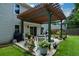 Backyard view with a wooden pergola, outdoor seating, and a grill, surrounded by lush green grass at 1777 Chasewood Park Ln, Marietta, GA 30066