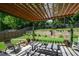 Comfortable patio area with a wooden pergola providing shade, with a view of the landscaped backyard at 1777 Chasewood Park Ln, Marietta, GA 30066