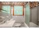 Cozy bathroom featuring floral wallpaper, gray tiles, window, and shower-tub combo at 2201 Bollingbrook Drive, Atlanta, GA 30311