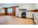Kitchen featuring wood paneling, linoleum flooring, white cabinets, and black appliances at 2201 Bollingbrook Drive, Atlanta, GA 30311