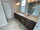 Bathroom with double vanity, marble countertops, gray cabinets, and large, framed mirrors at 996 Layton Dr, Buford, GA 30518