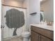 A well-lit bathroom with a tree-themed shower curtain, and a brown vanity with a white countertop at 996 Layton Dr, Buford, GA 30518