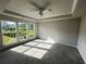 Spacious bedroom with tray ceilings, ceiling fan and three large windows overlooking a green backyard at 996 Layton Dr, Buford, GA 30518