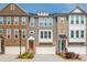 View of townhomes with attached garages, varied brick and siding, manicured landscaping, and colorful front doors at 996 Layton Dr, Buford, GA 30518