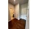 Hallway with hardwood flooring leading to a bathroom with a tub-shower and a white door at 996 Layton Dr, Buford, GA 30518