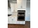 Gourmet kitchen with built-in stainless steel appliances and white cabinets at 996 Layton Dr, Buford, GA 30518