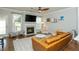 Cozy living room with fireplace, large windows, hardwood floors, and a comfortable leather sofa at 996 Layton Dr, Buford, GA 30518