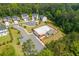 Aerial view of a community pool with ample parking, bath house, and well-manicured landscaping surrounded by trees and homes at 996 Layton Dr, Buford, GA 30518