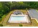 A beautiful community pool area with a bath house, lounge chairs, and tables surrounded by green space and trees at 996 Layton Dr, Buford, GA 30518
