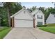 Two story traditional home with brick accents, attached garage and driveway with an expansive lawn at 1047 Woodsong Pass Ct, Lawrenceville, GA 30043