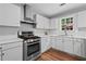 Clean kitchen featuring a stainless steel range hood and a view from the window at 1047 Woodsong Pass Ct, Lawrenceville, GA 30043