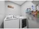 Modern laundry room featuring a washer and dryer, plus storage shelves at 1047 Woodsong Pass Ct, Lawrenceville, GA 30043